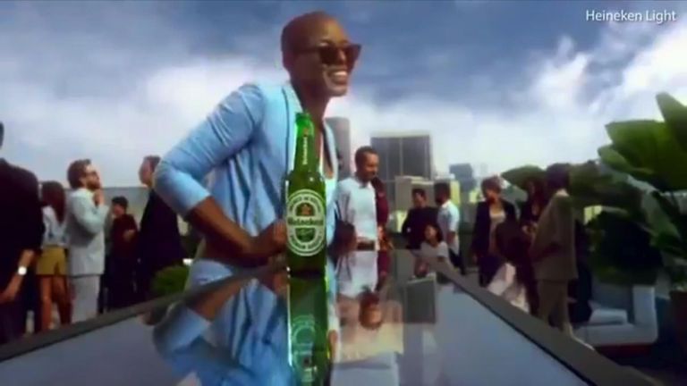 The bottle passes several black people before reaching the woman. Pic: Heineken
