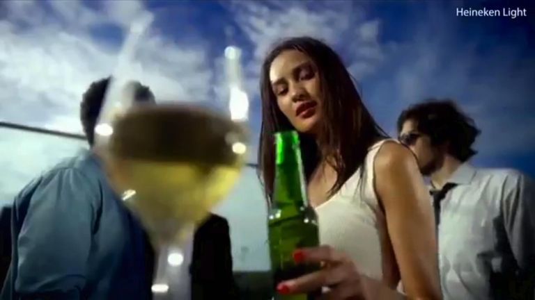 The bottle is passed to a light-skinned woman. Pic: Heineken