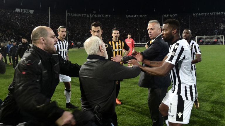 Paok president Ivan Savvidis takes to the pitch carrying a handgun in his waistband