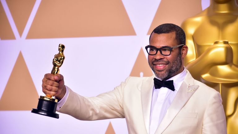 Director Jordan Peele poses in the press room with the Oscar for best original screenplay