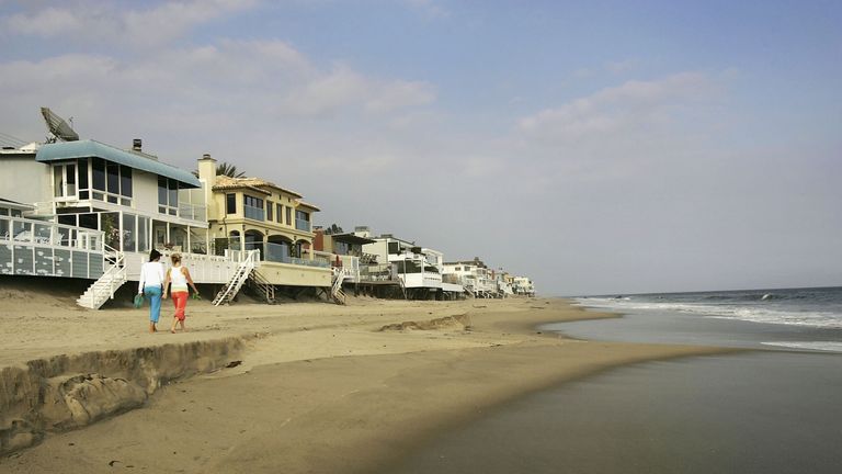 MALIBU, CA - APRIL 18:  Luxurious beach houses crowd the shoreline hiding Carbon Beach, a public beach that was gotten to through a recently opened public accessway next to music producer David Geffen&#39;s beach house, on April 18, 2005 in Malibu, California. The gate was found re-locked later that afternoon. By opening the gate, Geffen would be fulfilling a 22-year-old legal promise to open a public pathway across his property in exchange for permits from the Coastal Commission to begin building his Cape Cod-style compound across multiple lots on Carbon Beach. In giving up the gate key, the music mogul also stops daily fines of $1,000 a day from accumulating.  (Photo by David McNew/Getty Images)