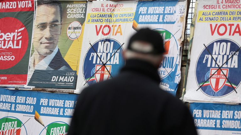 A man stands to look electoral posters in Pomigliano D&#39;Arco, near Naples, Italy, February 21, 2018