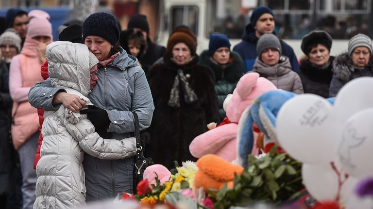 People grieve at a makeshift memorial in Kemerovo