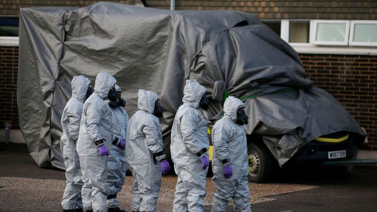 Personnel in protective coveralls and breathing equiptment cover an ambulance with a tarpaulin at the Salisbury District Hospital in Salisbury, southern England, on March 10, 2018