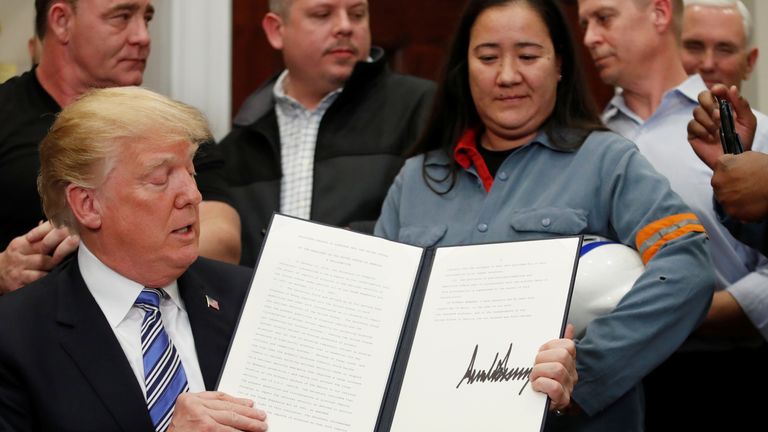 Donald Trump signs a presidential proclamation placing tariffs on aluminium and steel imports
