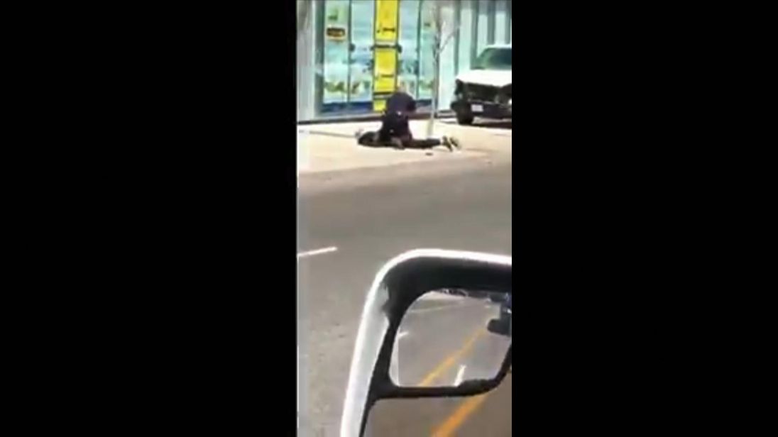 The Toronto suspect is restrained by a police officer