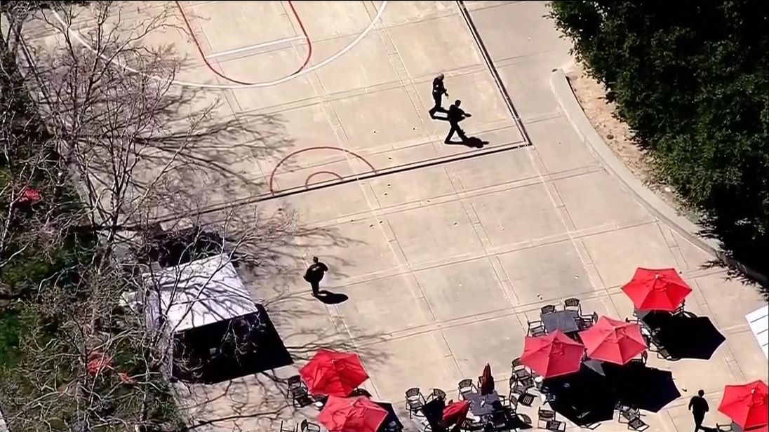 Police officers were seen with their guns drawn on the roof of the headquarters