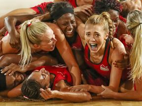 Helen Housby (R) is mobbed by her England teammates after the final ended