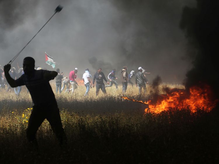 A Palestinian demonstrator uses a sling to hurl stones