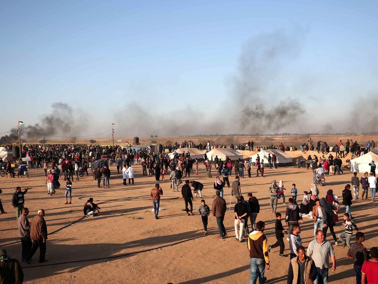 Palestinian protesters walk in a camp during clashes with Israeli security forces