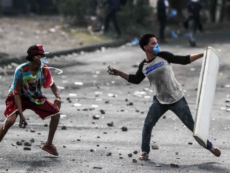 Students throw stones as they clash with police