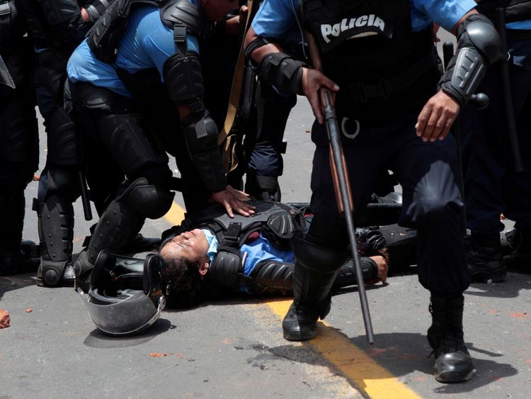 A riot policeman lies injured