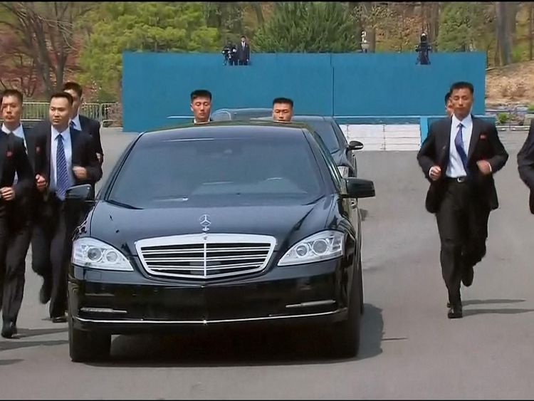 Security personnel jogged alongside Mr Kim&#39;s car as he went for lunch