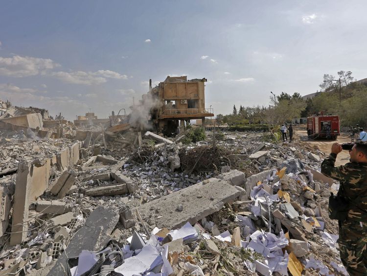 A Syrian soldier takes a picture of the wreckage of the research centre