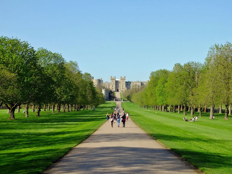 People enjoy the sunshine on the Long Walk at Windsor Castle in Berkshire