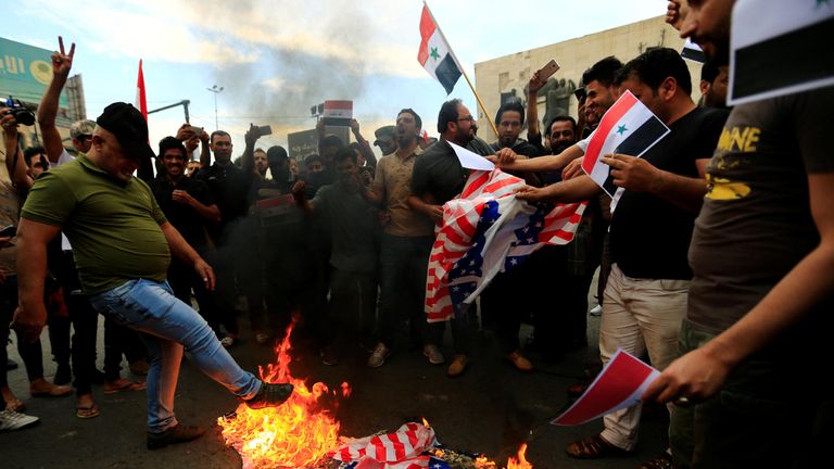 Protesters burn a US flag in Tahrir Square, Baghdad, Iraq