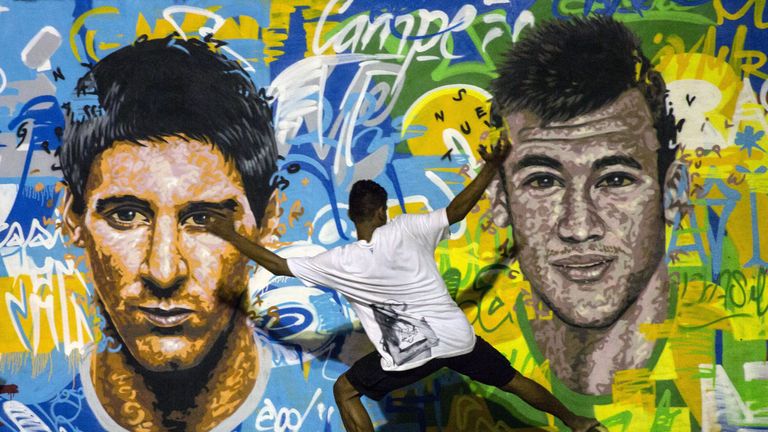 Youngsters play football in front of a mural of Argentine footballer Lionel Messi (L) and Brazil&#39;s Neymar