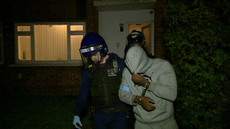 A suspect arrested during the raids is led away