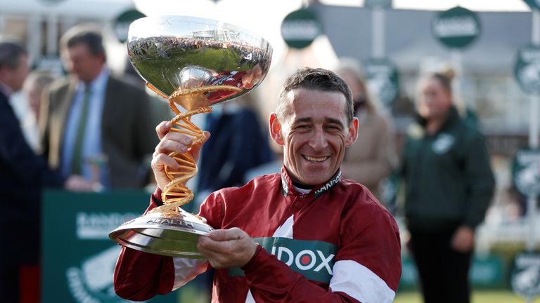 Davy Russell celebrates with a trophy after winning the 17:15 Randox Health Grand National Handicap Chase