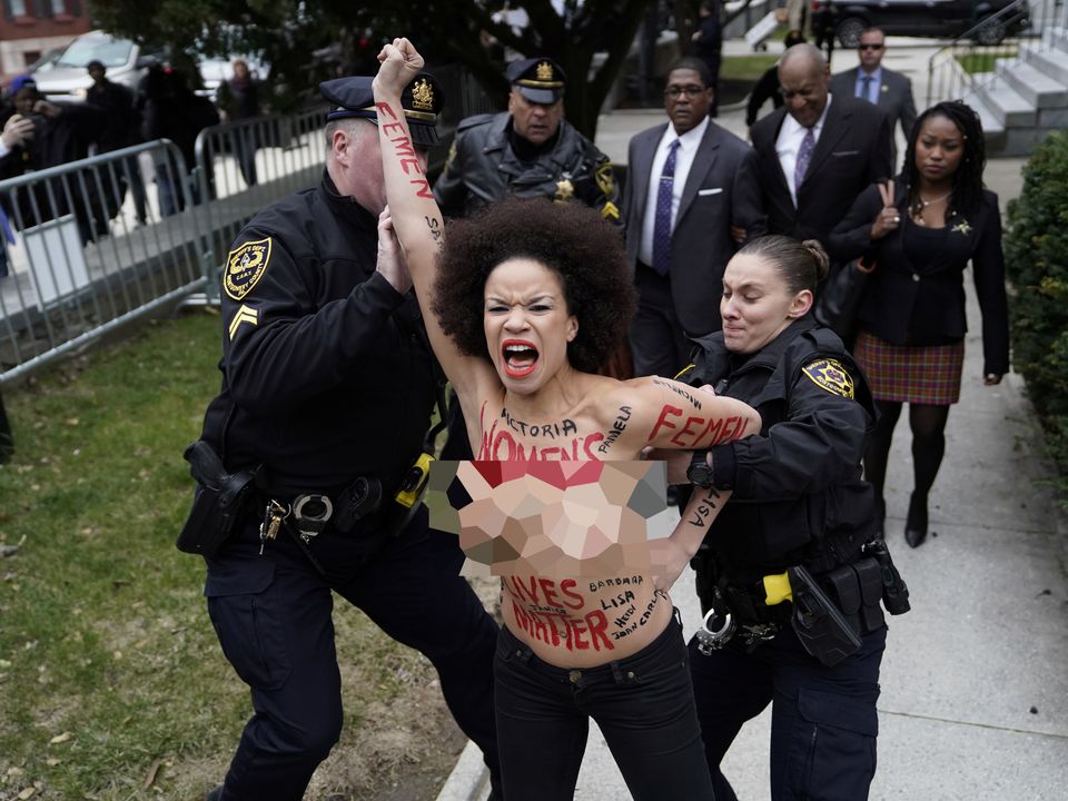 The protester is restrained by police outside the courthouse in Philadelphia