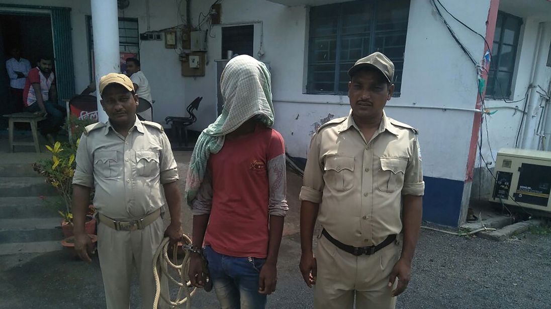 TOPSHOT - This photo taken on May 6, 2018 shows an alleged rapist (C) being held by Indian police, in the case of a 17-year-old girl who was raped and set on fire, at Mufasil police station before being sent to judicial custody in Pakur district, in India's eastern Jharkhand state. - A 17-year-old battled for her life May 7 after being raped, doused in kerosene and set on fire, the second such case to shake India as it battles an increase in sexual crimes. (Photo by - / AFP) (Photo credit should
