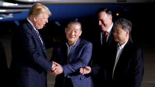 Donald Trump greets the Americans formerly held hostage in North Korea upon their arrival at Joint Base Andrews