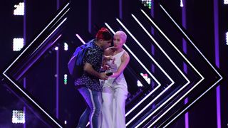 A man takes the microphone from Britain's singer Susanna Marie Cork aka SuRie as she performs 'Storm' during the final of the 63rd edition of the Eurovision Song Contest 2018 at the Altice Arena in Lisbon, on May 12, 2018. (Photo by Francisco LEONG / AFP) (Photo credit should read FRANCISCO LEONG/AFP/Getty Images)
