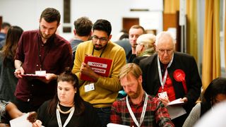 Volunteers count ballot papers at Wandsworth Town hall after local government elections in London