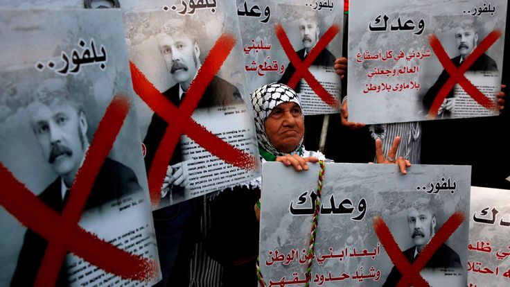 Palestinian demonstrators carry placards of British Prime Minister Balfour while protesting the Balfour Declaration