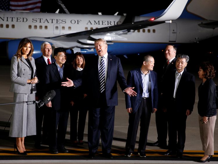 Donald Trump talks to the media next to the three Americans formerly held hostage in North Korea