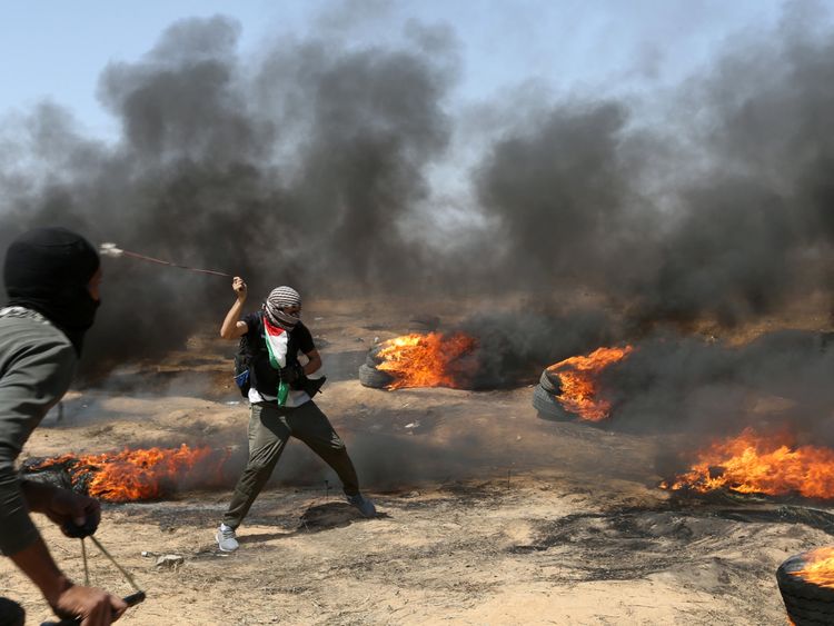 A demonstrator uses a sling to hurl stones at Israeli forces 