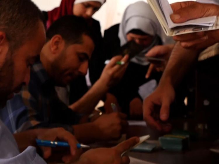 Palestinians try to get their documents in order so they can have a chance to get on a bus to Egypt