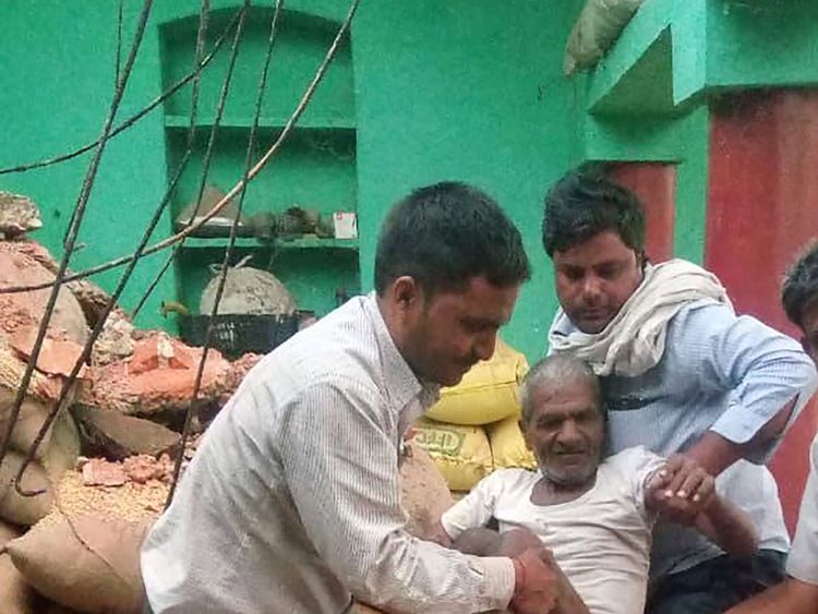 A man is carried from the debris of his damaged home following a major dust storm in Etmadpur, in Agra district in northern India&#39;s Uttar Pradesh state