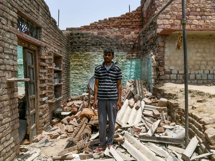 A man stands in the ruins of his house which was destroyed in the storms earlier this month