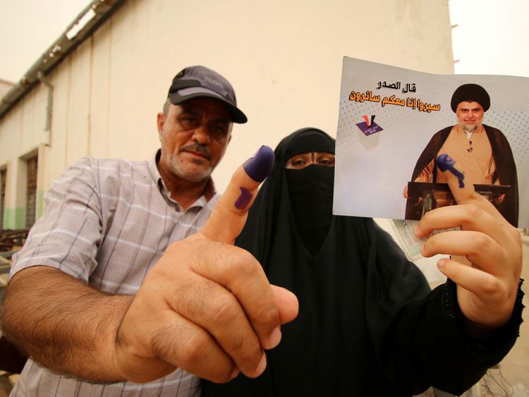 People show their ink-stained fingers after voting in Basra