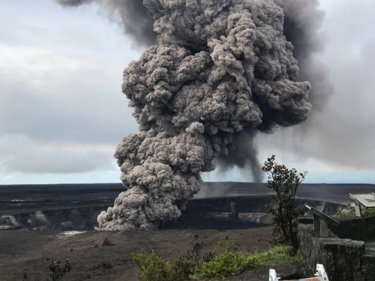An ash column rises from the volcano