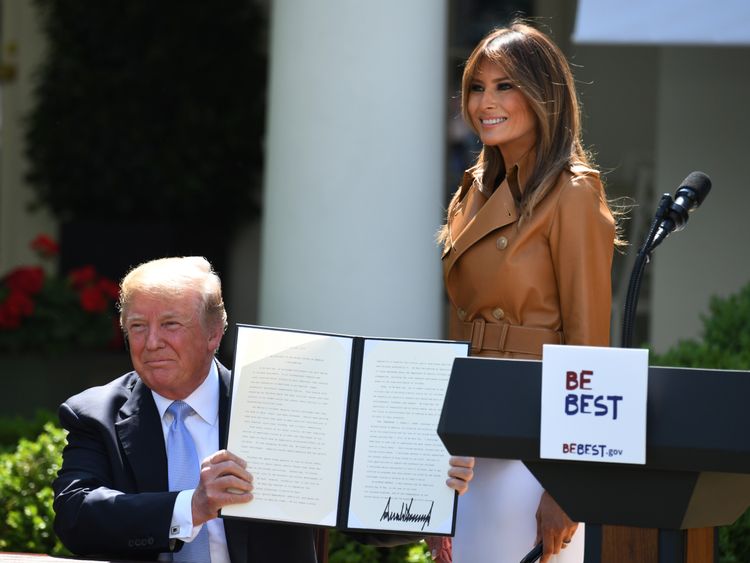 First Lady Melania Trump smiles as US President Donald Trump holds up his proclamation for 'National Be Best Day' 