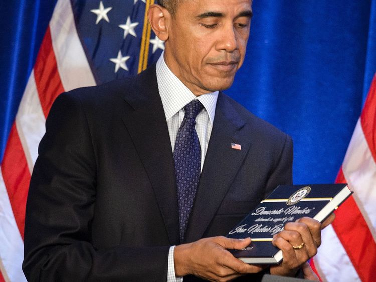US President Barack Obama holds a copy of the Iran nuclear agreement presented to him by House Minority Leader Nancy Pelosi (D-CA) during the House Democratic Issues Conference January 28, 2016 in Baltimore, Maryland. / AFP / Brendan Smialowski (Photo credit should read BRENDAN SMIALOWSKI/AFP/Getty Images)