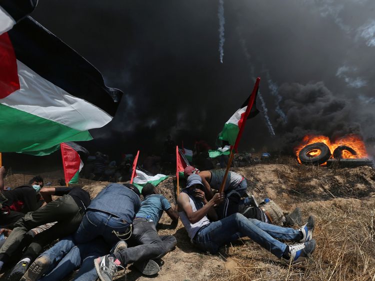 Palestinian demonstrators take cover from Israeli fire and tear gas during a protest against U.S. embassy move to Jerusalem and ahead of the 70th anniversary of Nakba, at the Israel-Gaza border in the southern Gaza Strip May 14, 2018