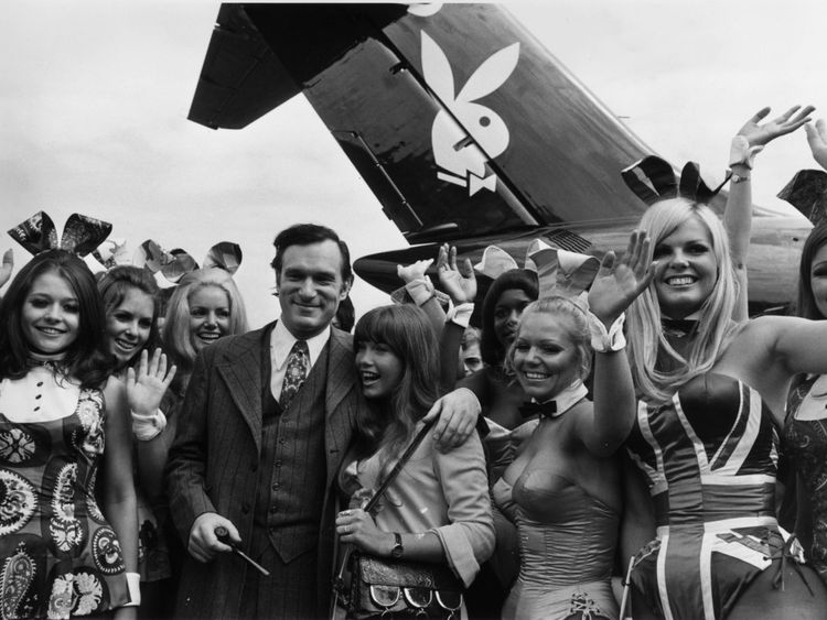 Hugh Hefner stand in front of a plane complete with the iconic Playboy logo
