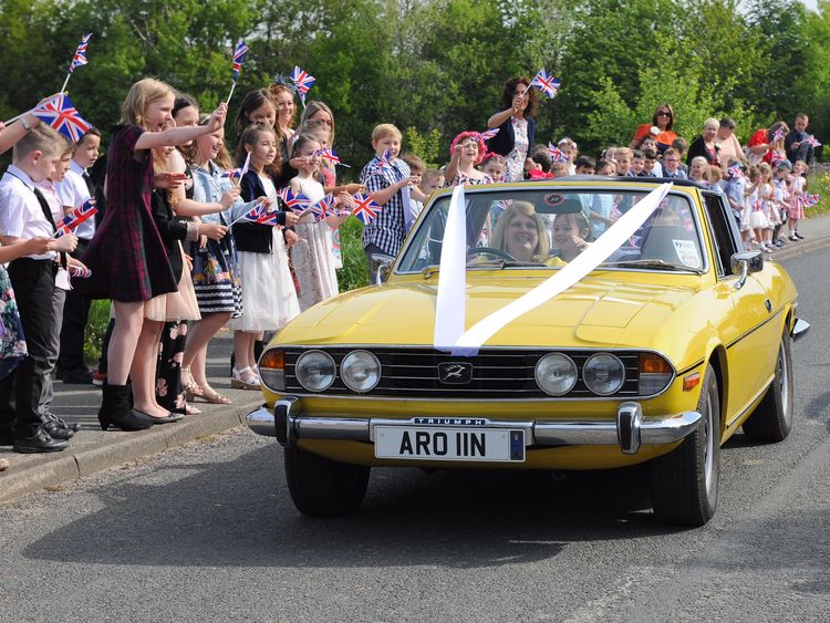 The bride and the 'father of the bride' are greeted by a street-lined procession