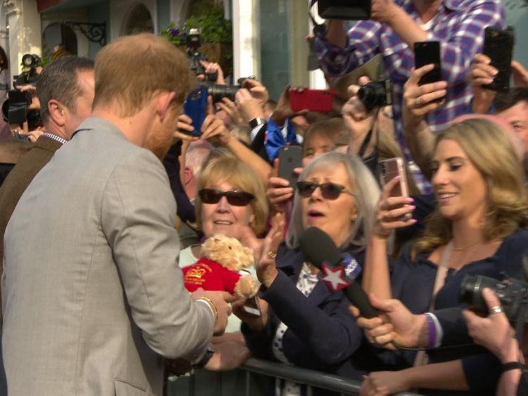Prince Harry is given a teddy bear by a fan