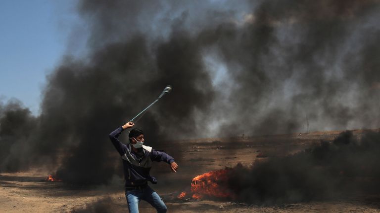 A Palestinian man uses a slingshot during clashes with Israeli forces along the border with the Gaza strip east of Khan Yunis