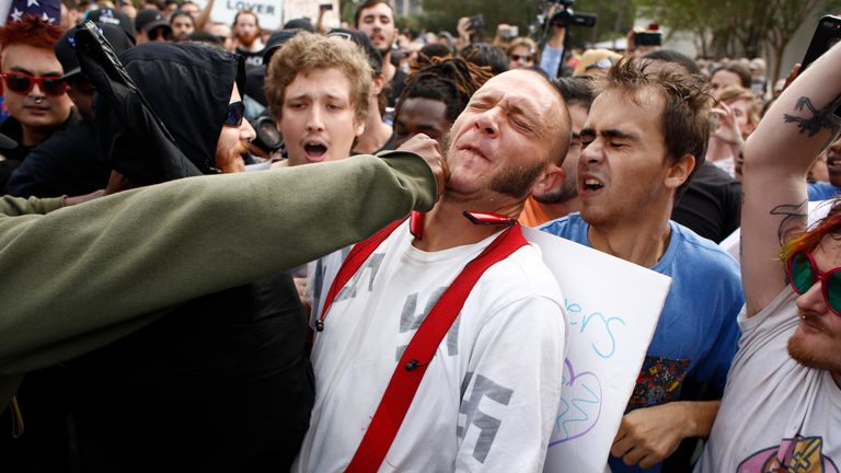 GAINESVILLE, FL - OCTOBER 19: A man wearing a shirt with swastikas on it is punched by an unidentified member of the crowd near the site of a planned speech by white nationalist Richard Spencer, who popularized the term &#39;alt-right&#39;, at the University of Florida campus on October 19, 2017 in Gainesville, Florida. A state of emergency was declared on Monday by Florida Gov. Rick Scott to allow for increased law enforcement due to fears of violence. (Photo by Brian Blanco/Getty Images)
