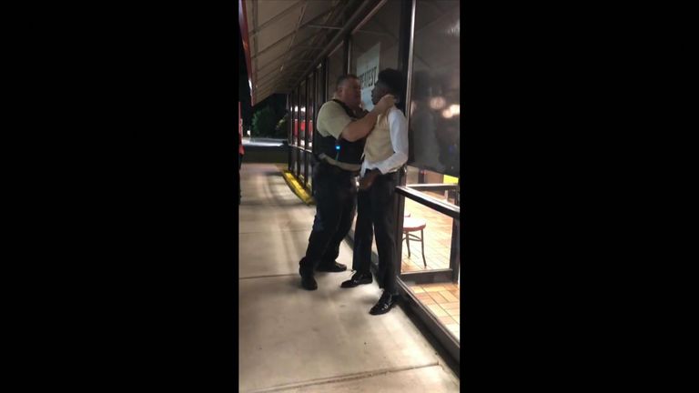 A US police officer has been filmed violently grabbing a black man by the throat outside a Waffle House in Warsaw, North Carolina. Pic: Anthony Wall/Facebook