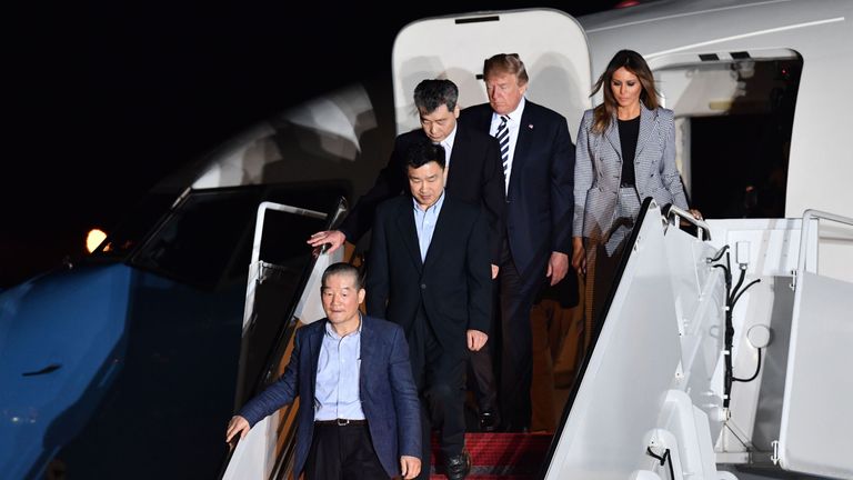 Donald Trump and his wife Melania walk down the stairs with US detainees