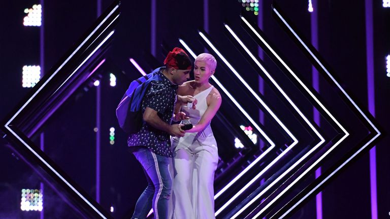 A man takes the microphone from Britain&#39;s singer Susanna Marie Cork aka SuRie as she performs &#39;Storm&#39; during the final of the 63rd edition of the Eurovision Song Contest 2018 at the Altice Arena in Lisbon, on May 12, 2018. (Photo by Francisco LEONG / AFP) (Photo credit should read FRANCISCO LEONG/AFP/Getty Images)