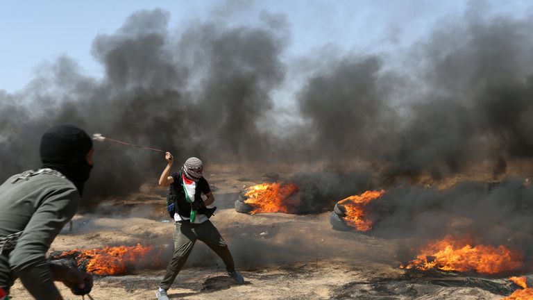 A demonstrator uses a sling to hurl stones at Israeli forces 