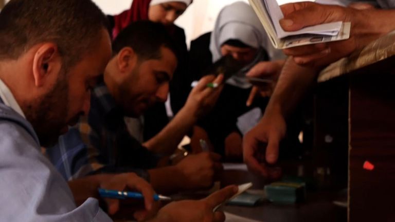 Palestinians try to get their documents in order so they can have a chance to get on a bus to Egypt