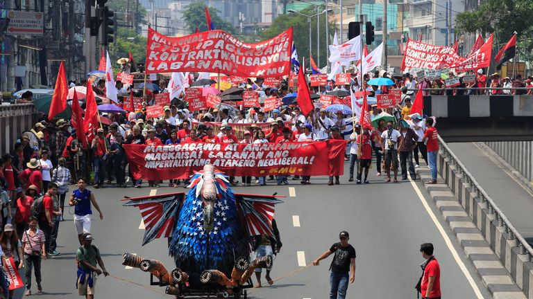 An effigy of a vulture in U.S. flag colors is pulled in front of various workers&#39; groups marching during the annual Labor Day protest march in metro Manila, Philippines May 1, 2017. The banner reads: "Workers unite against the imperialist attack of the neoliberal"